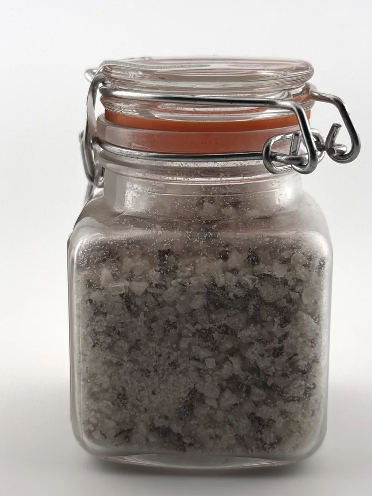 Back of the clear Keep It Savory jar showing coarse salt and dark mushroom pieces