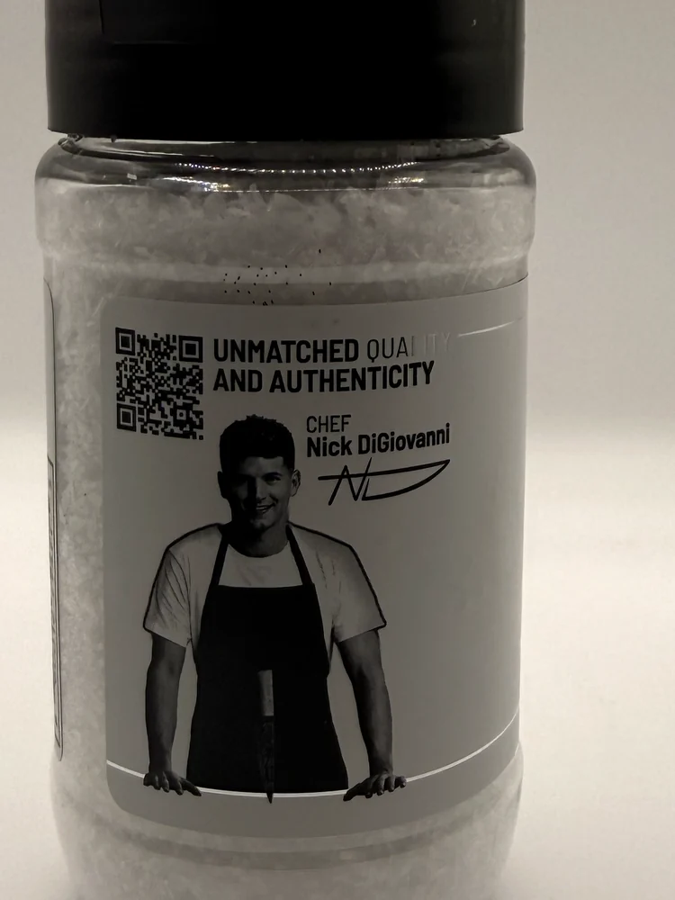 Back of the OSMO salt jar with a portrait and signature of chef Nick DiGiovanni